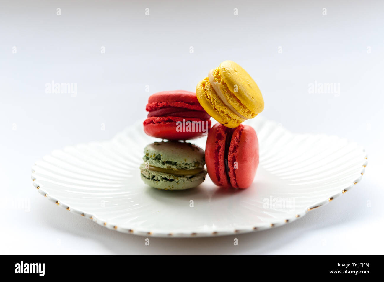 Macaron colorati su un vintage piastra bianca Foto Stock