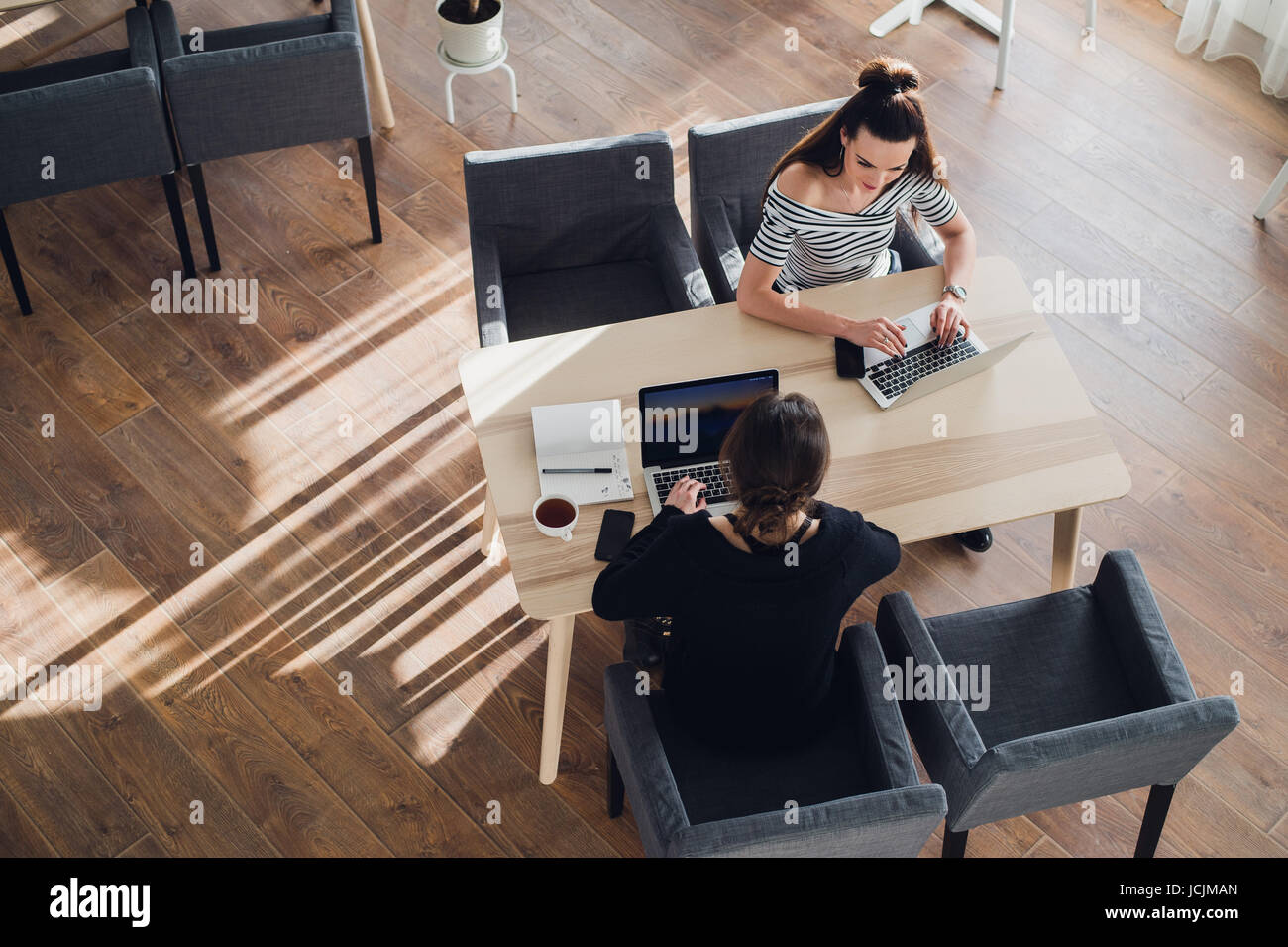 Due donne sono seduti al tavolo e discutere i problemi del lavoro e risolvere le questioni del lavoro. Foto Stock