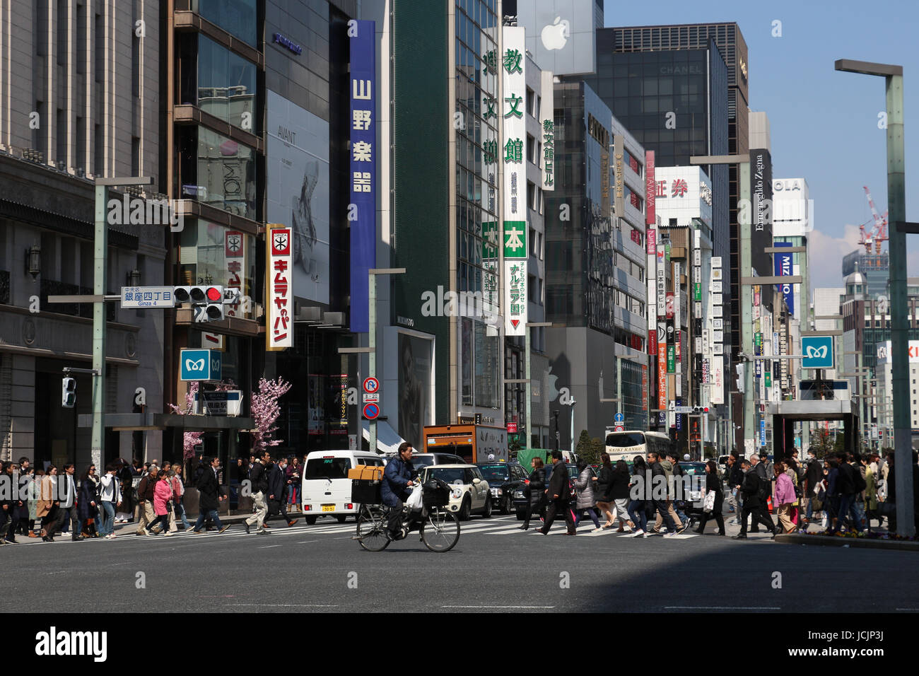 Strada trafficata scena a Tokyo in Giappone dove il traffico e i pedoni vie tor lo spazio in questa affollata capitale metropolitano in una giornata di sole. Foto Stock