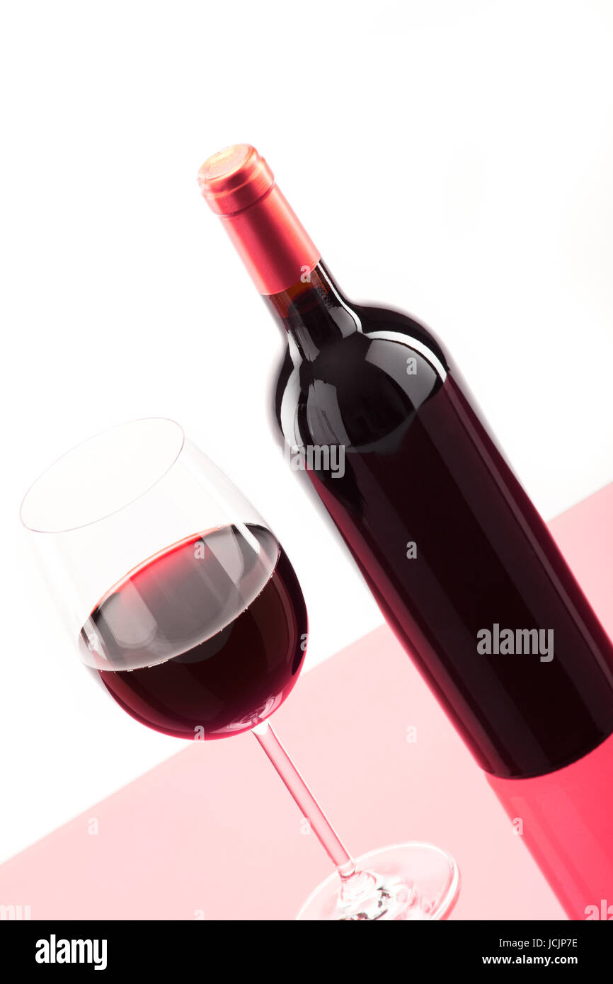 Ein Glas Rotwein mit Flasche daneben Foto Stock