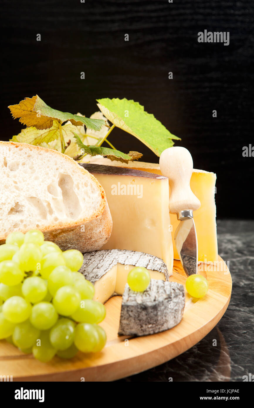 Käseplatte mit Weintrauben und Weissbrot Foto Stock