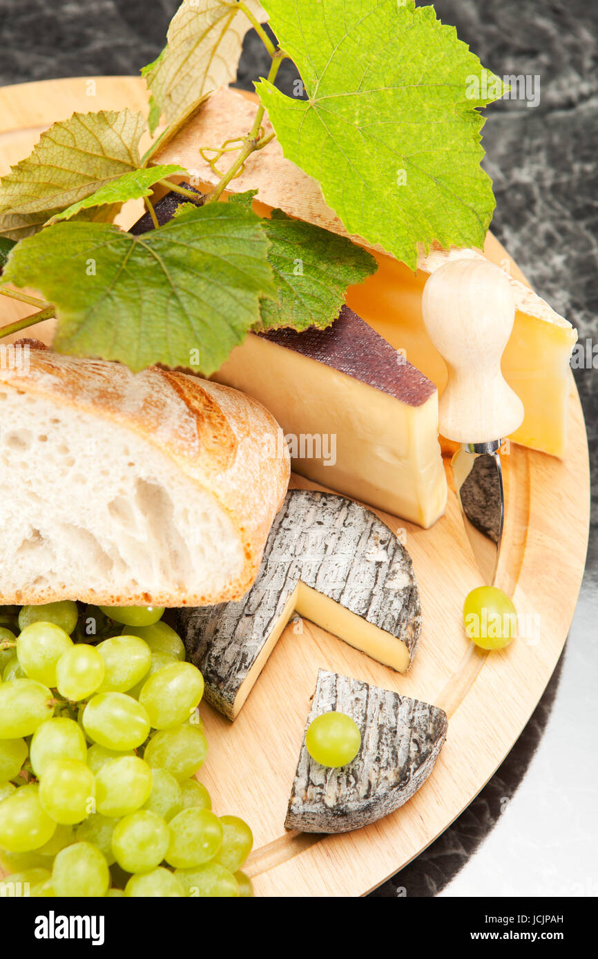 Käseplatte mit Weintrauben und Weissbrot Foto Stock