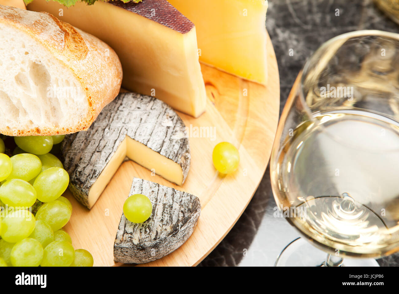 Weisswein mit Käseplatte Trauben und Weissbrot Foto Stock