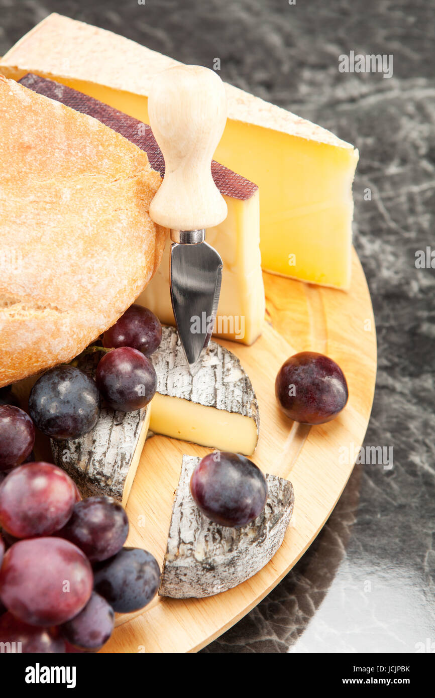 Käseplatte mit roten Weintrauben und Weissbrot Foto Stock