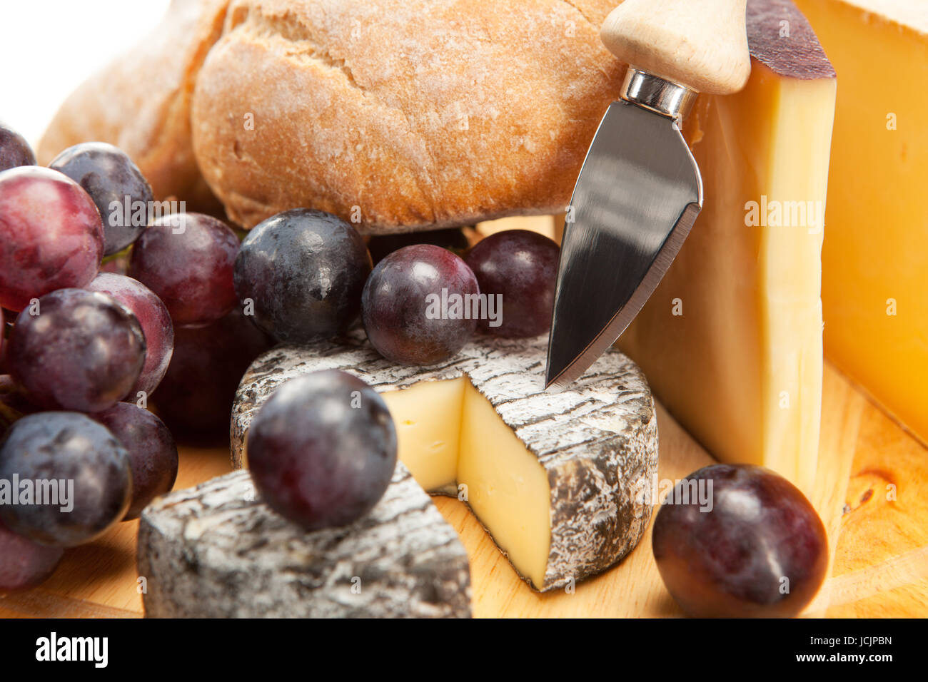 Käseplatte mit roten Weintrauben und Weissbrot Foto Stock