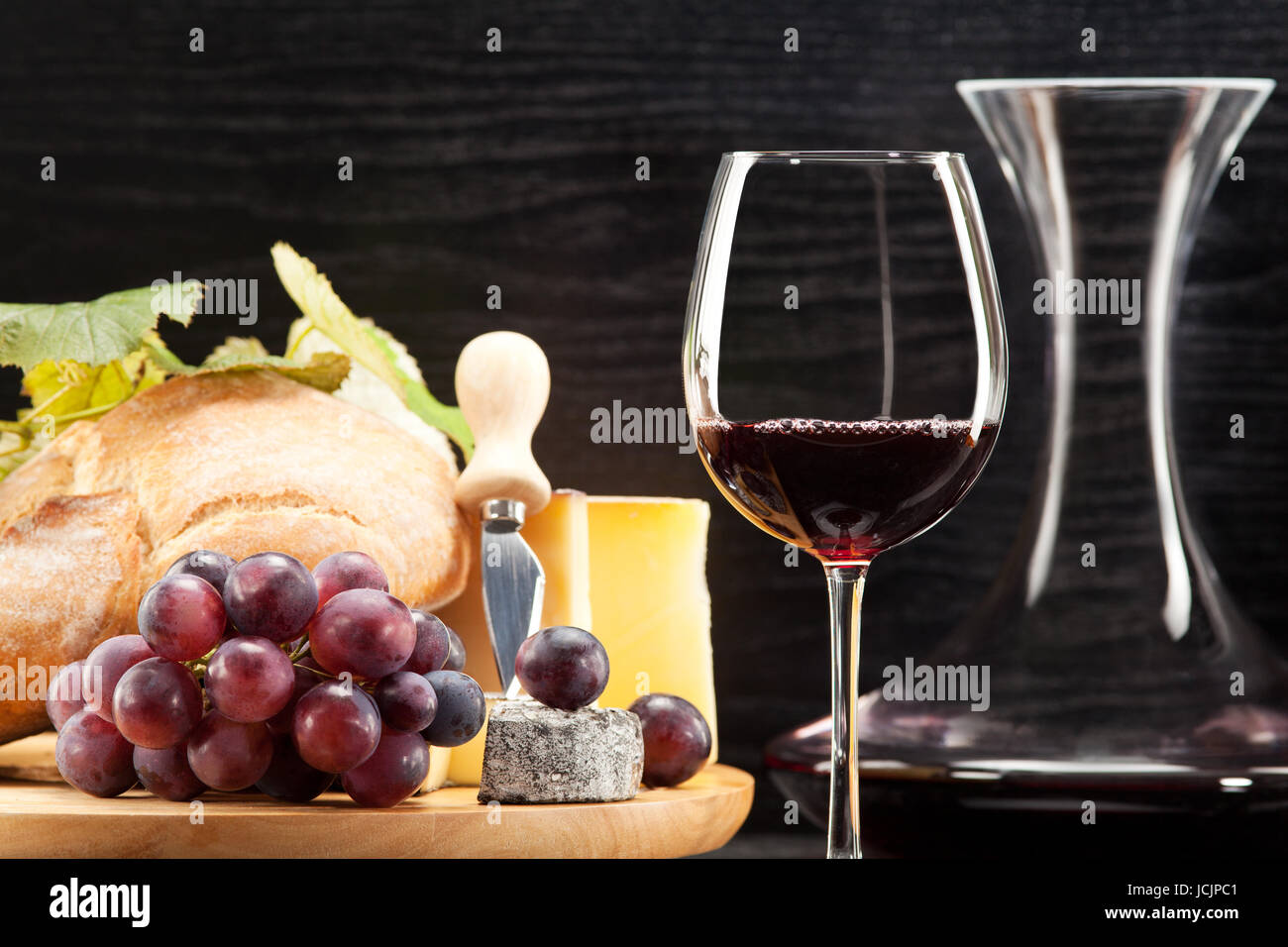 Rotwein mit Käseplatte Weintrauben und Brot Foto Stock