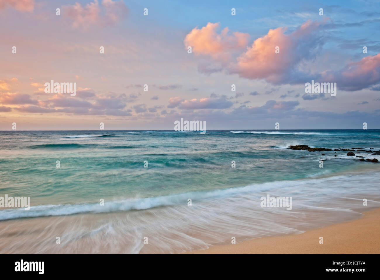 Sunrise offre una tavolozza di colori presso Poipu Beach lungo la riva sud alle Hawaii dell Isola di Kauai. Foto Stock