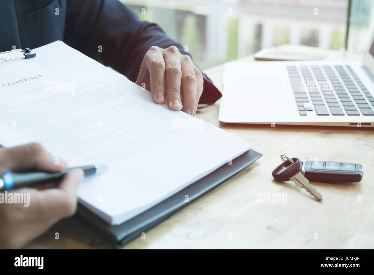 Giovane imprenditore presente la firma del contratto di vendita con chiave auto al cliente presso l'ufficio. proprietà, di acquisto del cliente venditore e vendita del servizio di trasporto di co Foto Stock