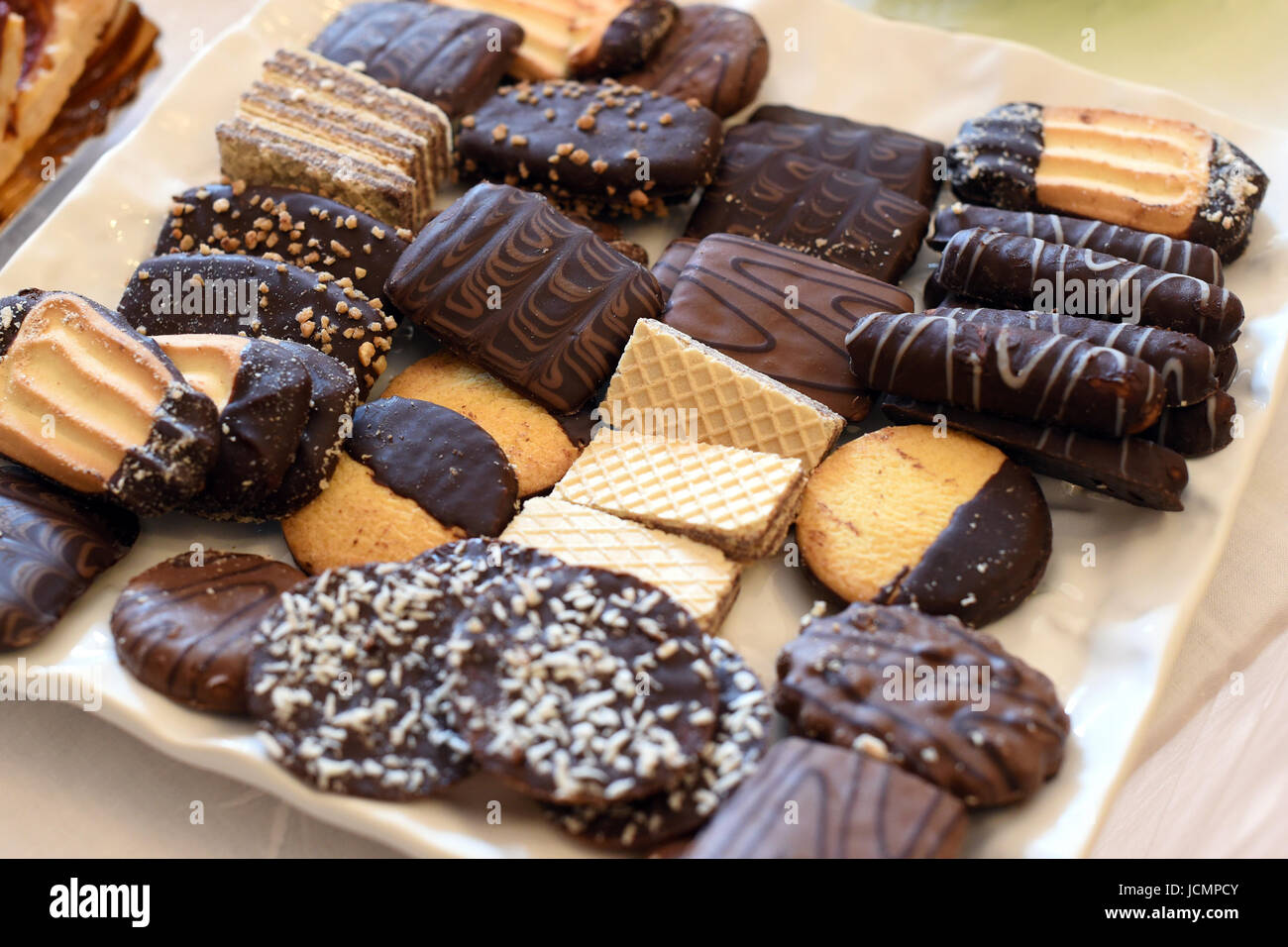 Vassoio con fresca assortita dolci al cioccolato e caramelle sul tavolo da buffet pronto per essere servito per dessert o con una bevanda calda Foto Stock