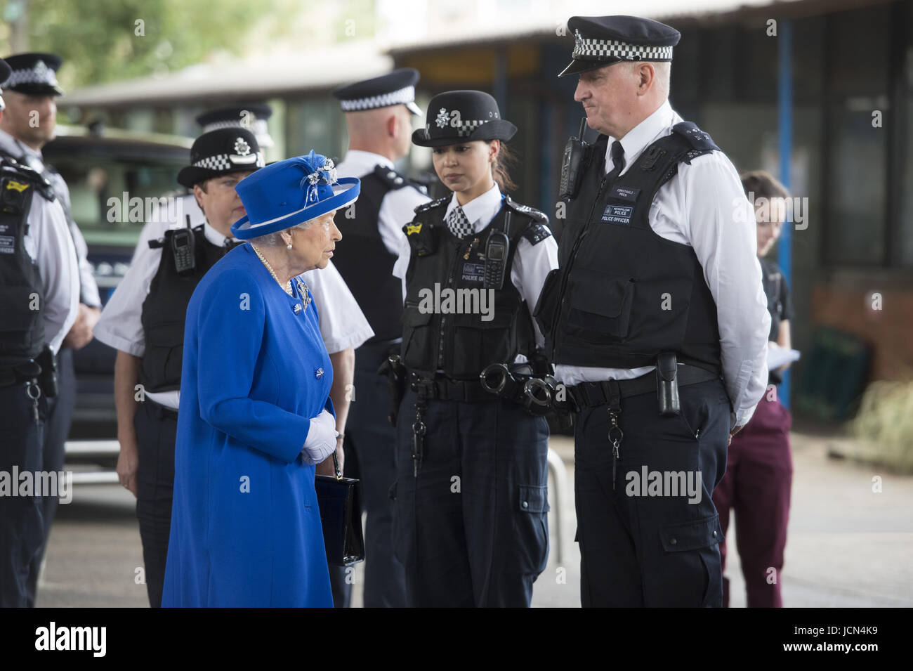 La regina Elisabetta II parla al personale dei servizi di emergenza come lei arriva per incontrare i membri della comunità interessata dall'incendio a Torre Grenfell nella zona ovest di Londra in occasione di una visita alla Westway centro sportivo che è quello di fornire un ricovero temporaneo per coloro che sono state rese senzatetto nel disastro. Foto Stock