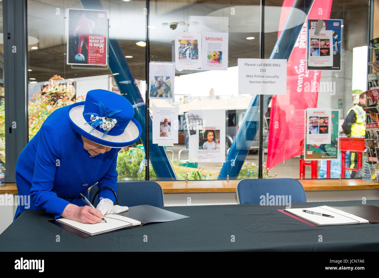 Queen Elizabeth II firma un libro di condoglianze durante una visita alla Westway Sports Centre di Londra, che è quello di fornire un ricovero temporaneo per coloro che sono state rese senzatetto nella torre Grenfell disastro. Foto Stock