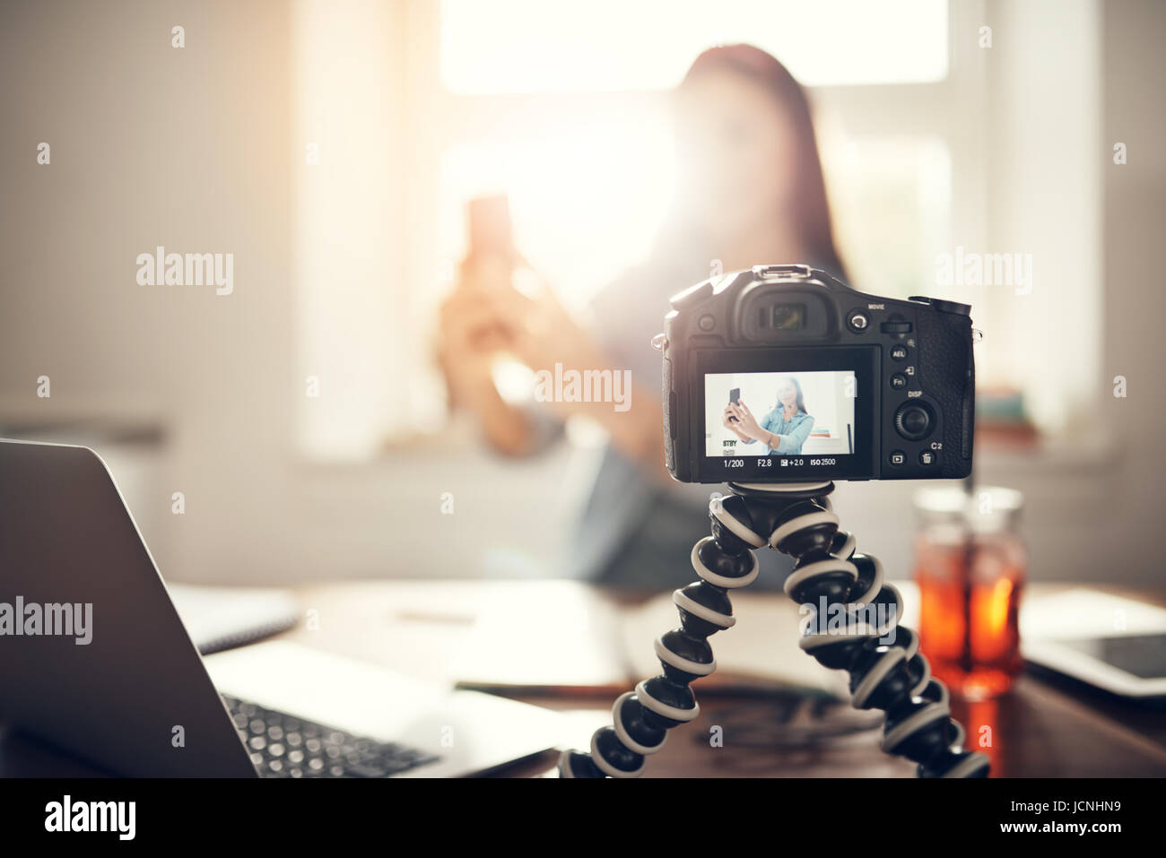 La registrazione della videocamera giovani blogger femminile prendendo un selfie mentre si effettua un podcast video. Foto Stock