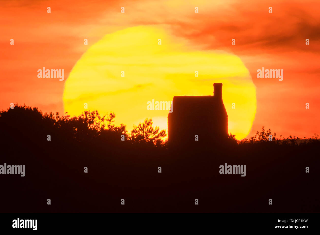 Puncknowle, Dorset, Regno Unito. Il 16 giugno 2017. Regno Unito Meteo. Un cielo fiery al tramonto quando il sole tramonta dietro al livello alto nuvole sopra il Knowle a Puncknowle nel Dorset dopo una giornata di caldo sole pomeridiano all'inizio di quello che sembra essere un bruciante weekend. Credito Foto: Graham Hunt/Alamy Live News Foto Stock