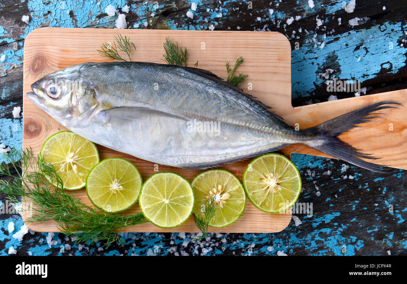 Pesce di carangidi jack o congelate in ghiaccio con limone e sale freschi dal mercato della pesca pronti per la cottura. Foto Stock