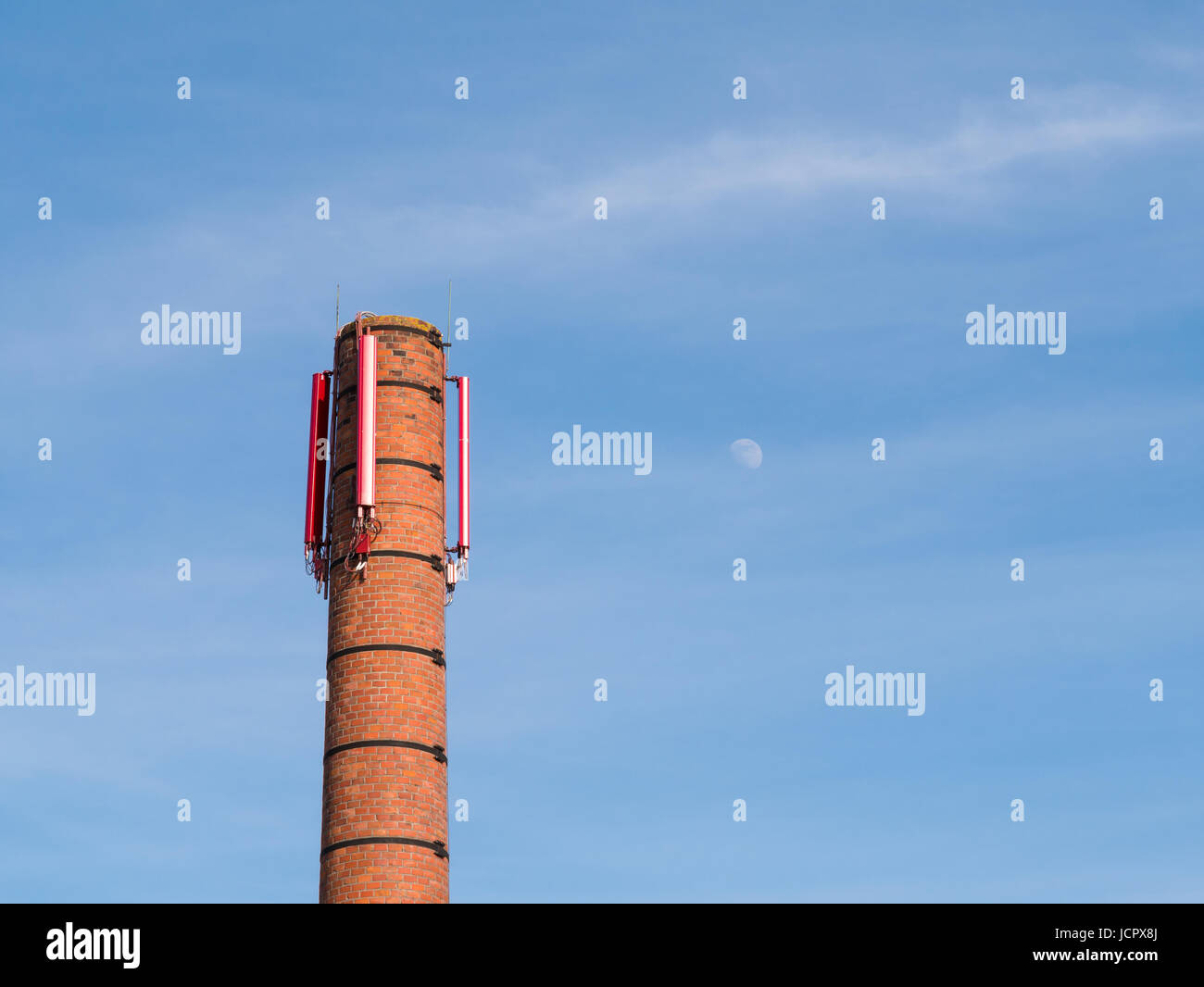Vecchia pila con la telefonia mobile trasmettitore contro il cielo blu e la luna, Paesi Bassi Foto Stock