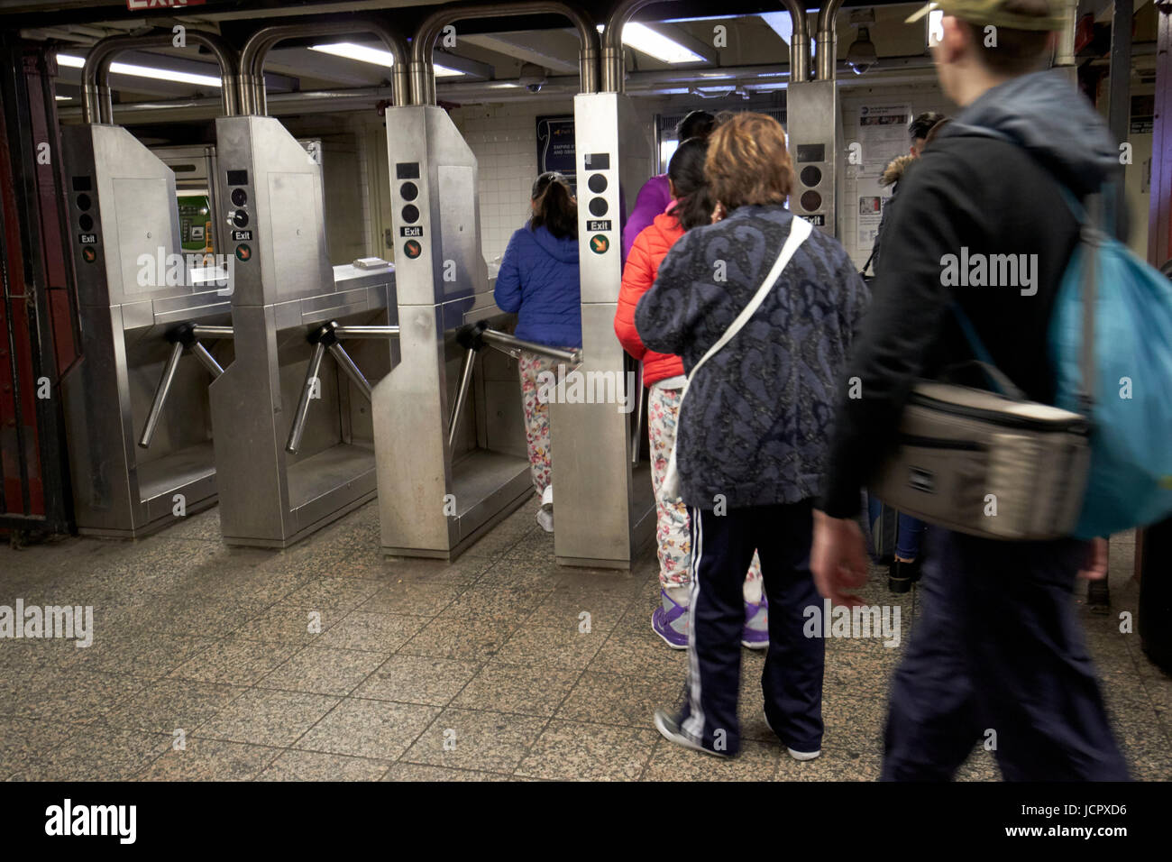 I passeggeri si muove attraverso l'uscita tornelli nella stazione della metropolitana di New York City STATI UNITI D'AMERICA Foto Stock