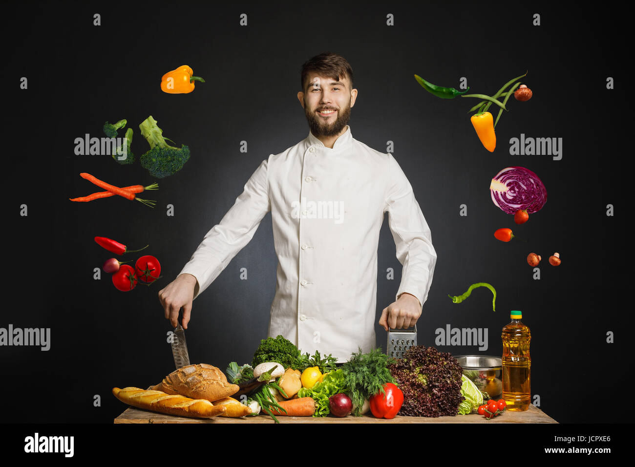 L'uomo Cook detiene una padella con verdure volare in aria. Cibo armonia musicale. L'uomo cuochi in cucina. Persone, cucina, della cucina e del concetto di cibo. Ch Foto Stock