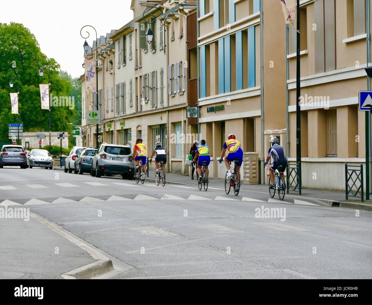 I ciclisti in sella attraverso la cittadina di Auvers-sur-Oise, Francia. Foto Stock