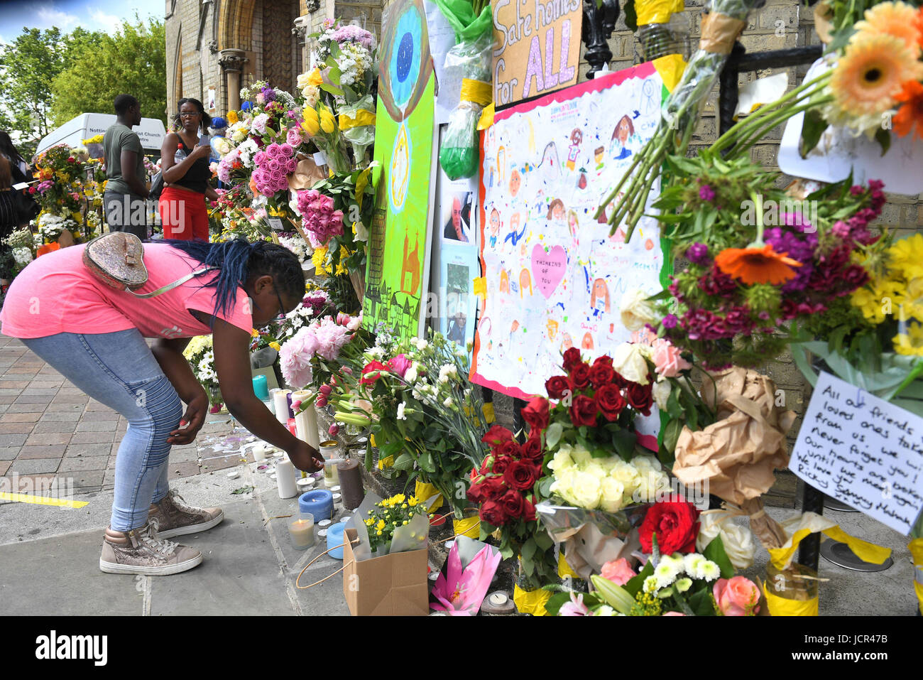 (Il consenso dei genitori dato) Avigail Cunningham 9, accende una candela accanto a tributi a Notting Hill Chiesa Metodista vicino Grenfell torre nella zona ovest di Londra dopo un incendio si propagò edificio a 24 piani sulla mattina di mercoledì. Foto Stock