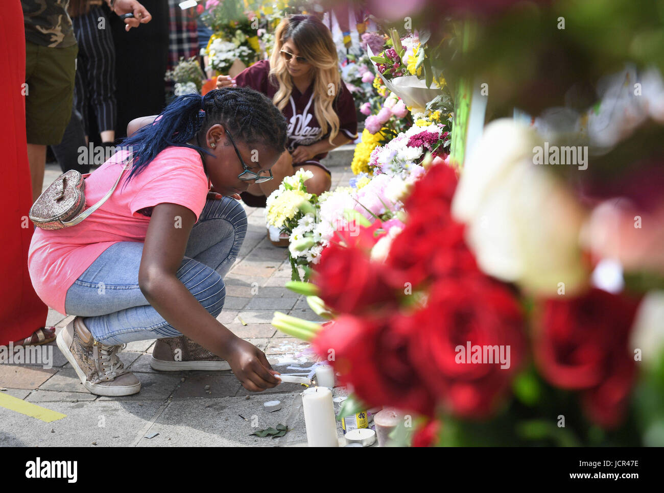 (Il consenso dei genitori dato) Avigail Cunningham 9, accende una candela accanto a tributi a Notting Hill Chiesa Metodista vicino Grenfell torre nella zona ovest di Londra dopo un incendio si propagò edificio a 24 piani sulla mattina di mercoledì. Foto Stock