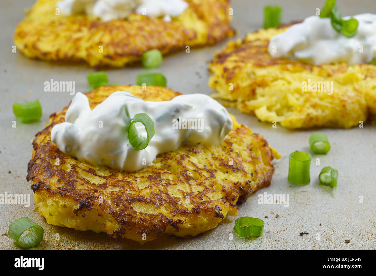 Zucca spaghetti dolci fritti con panna acida e le cipolle verdi su un bordo in metallo Foto Stock