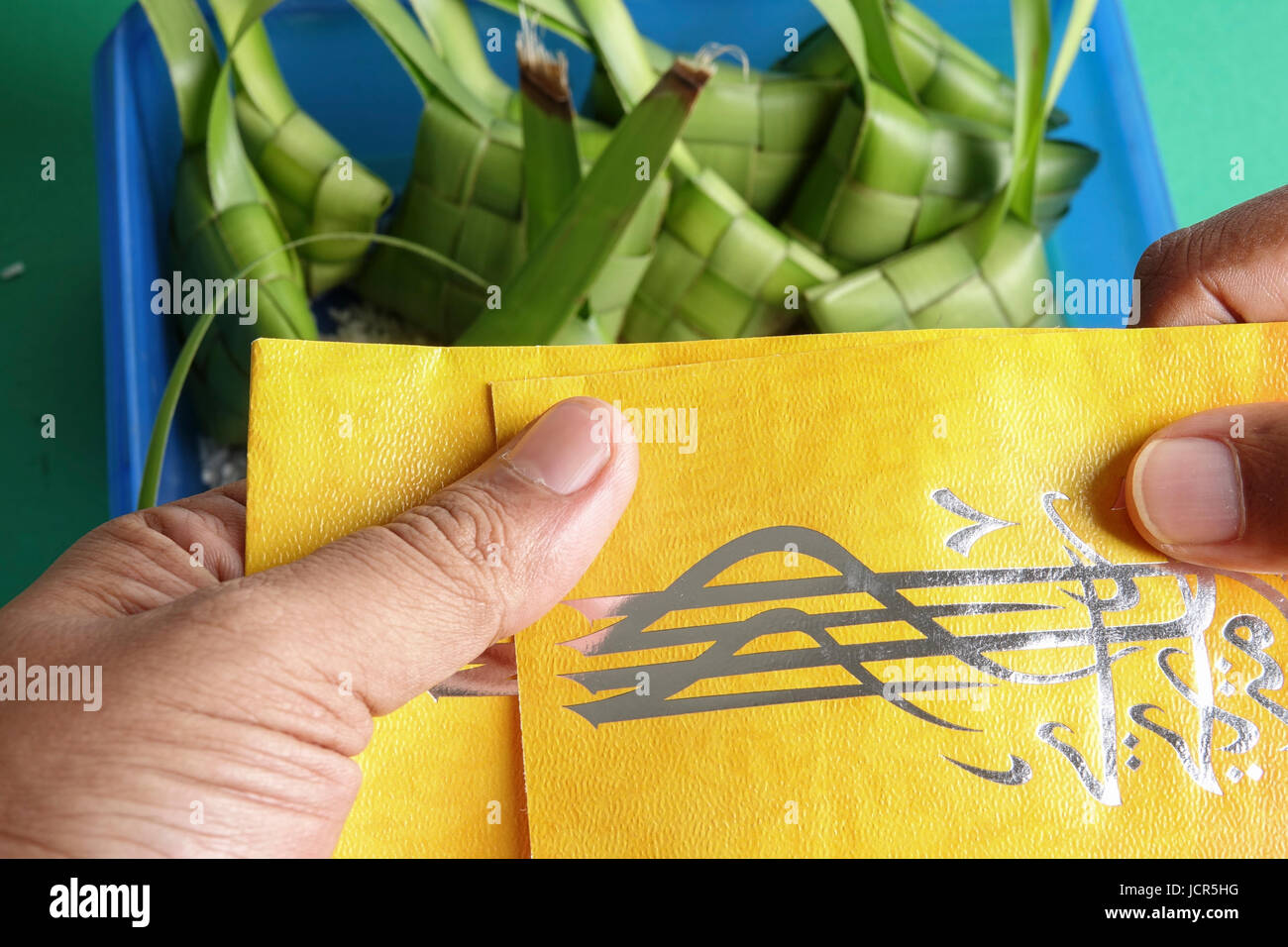 Dare e ricevere denaro pacchetto durante Eid Fitri. Carattere arabo significa Eid Mubarak Foto Stock