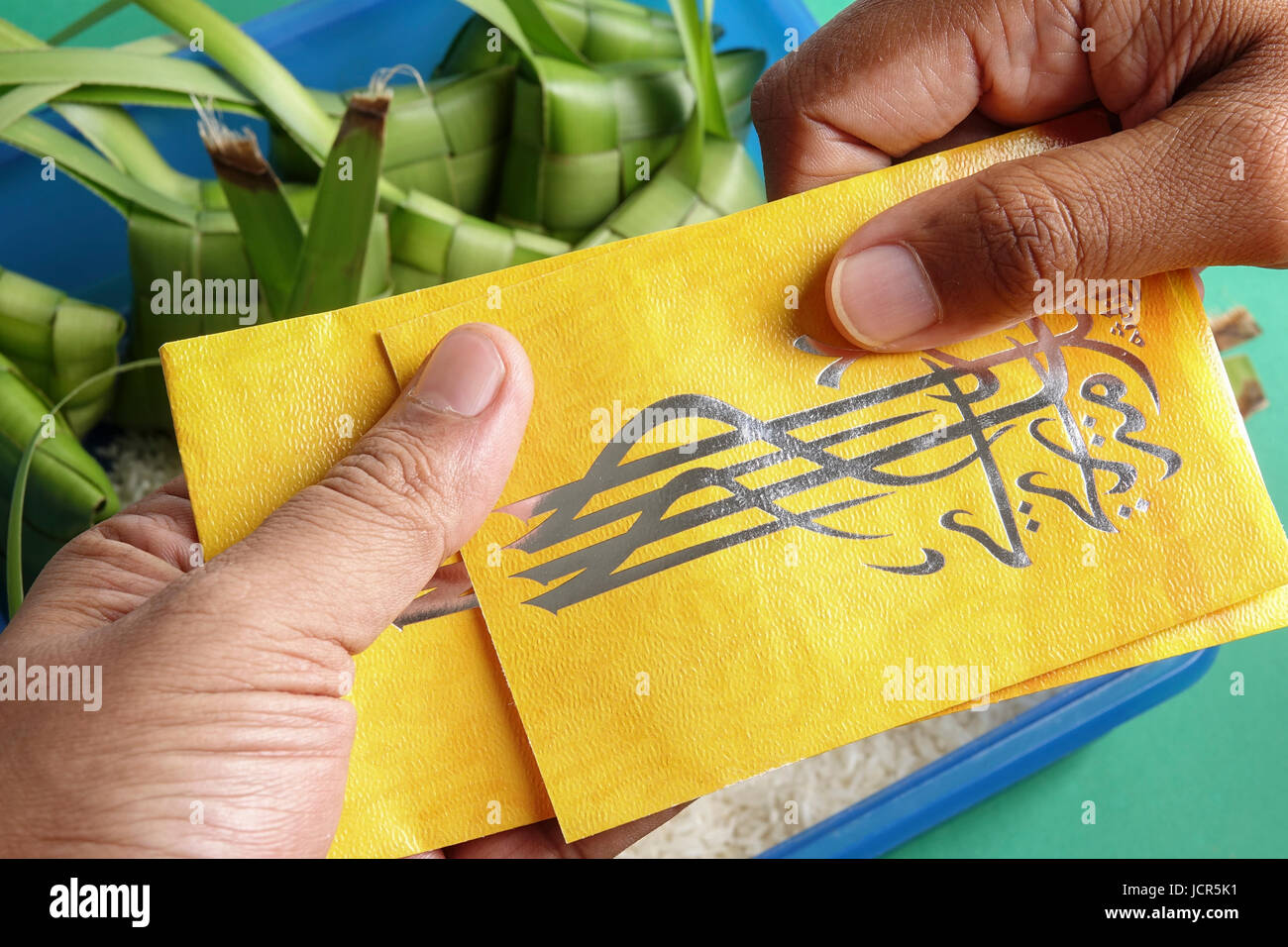 Dare e ricevere denaro pacchetto durante Eid Fitri. Carattere arabo significa Eid Mubarak Foto Stock