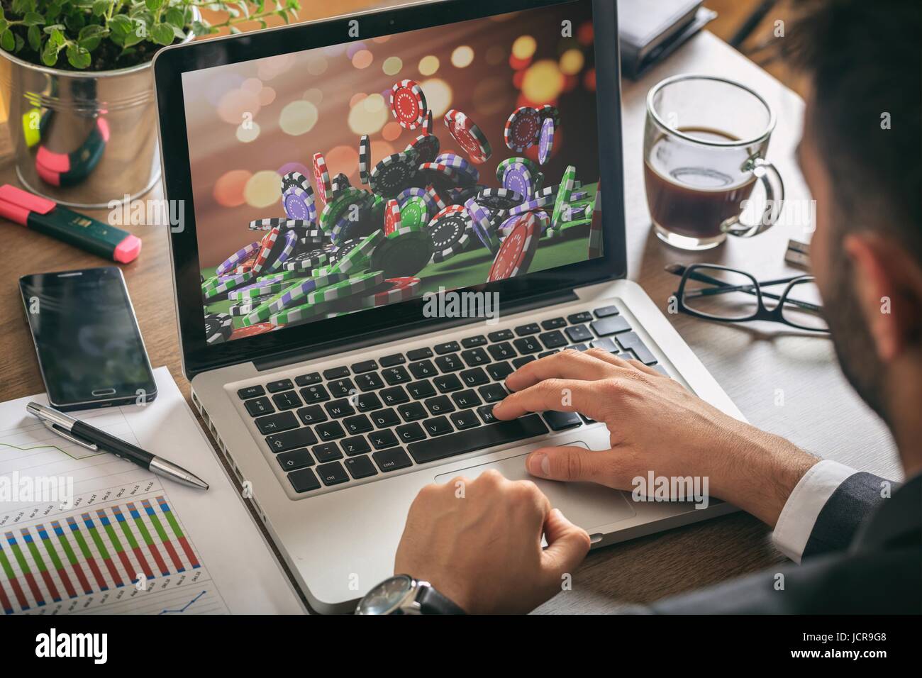 Il gioco d'azzardo online concetto. Uomo al lavoro - Chip Casino sullo schermo di un computer. Foto Stock