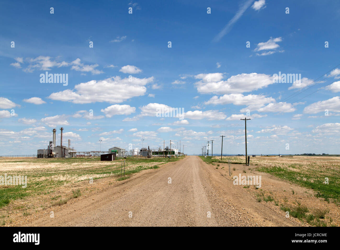 Impianto di alimentazione da una pista sterrata sotto un cielo blu nel deserto di Alberta, vicino Drumheller, in Canada Foto Stock