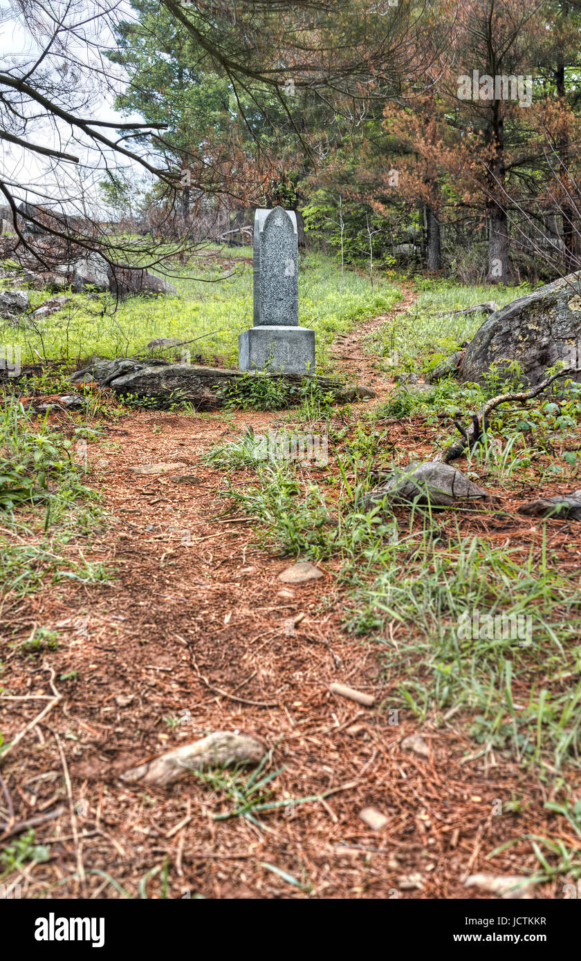 Il sentiero nel bosco che conduce al Little Round Top nel campo di battaglia di Gettysburg national park con pietre grave durante l'estate Foto Stock