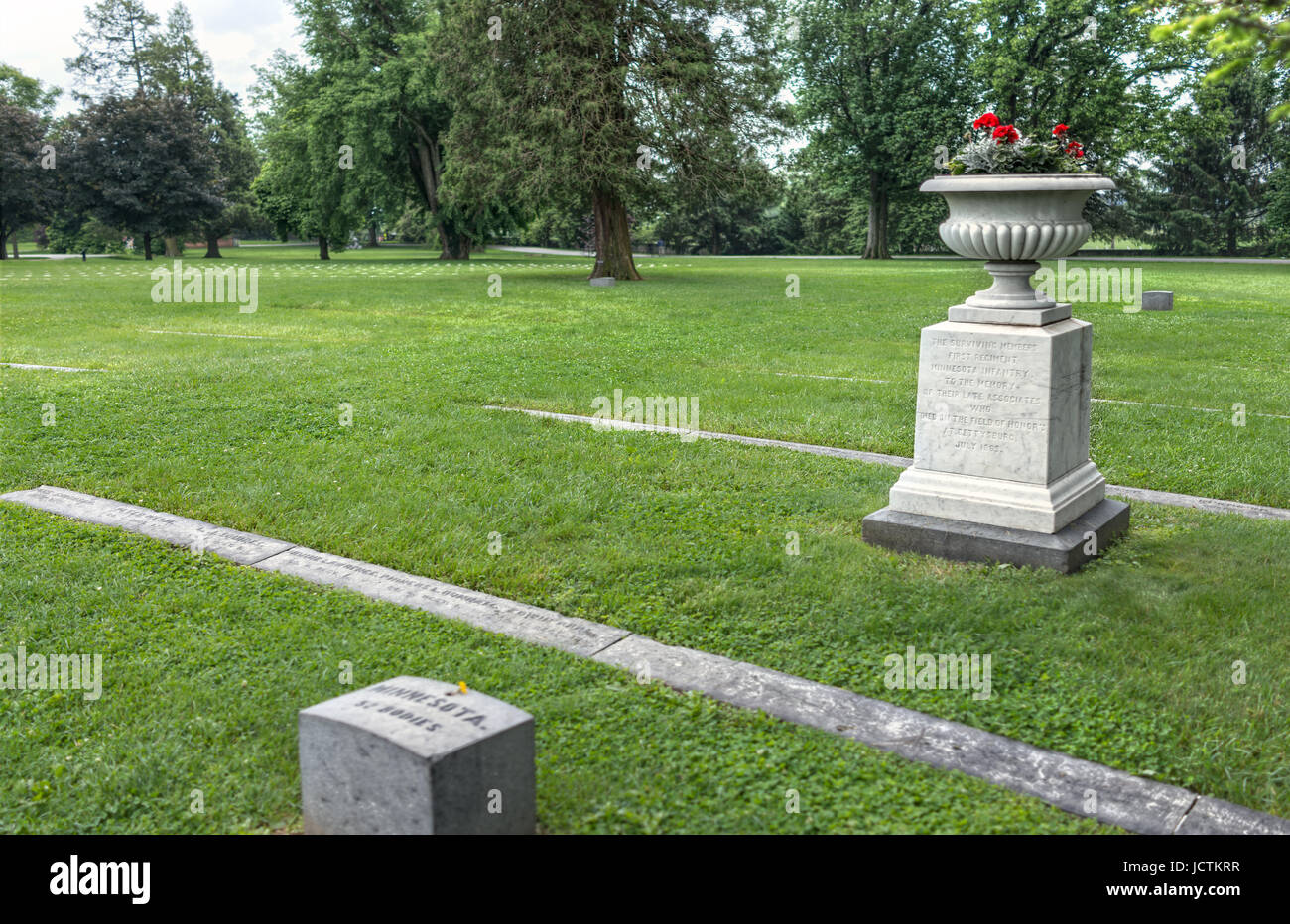 Gettysburg, Stati Uniti d'America - 24 Maggio 2017: Cimitero Nazionale di Gettysburg battlefield park con molte e gravi le pietre e i siti e fiori di colore rosso con la fanteria Minnesota Foto Stock