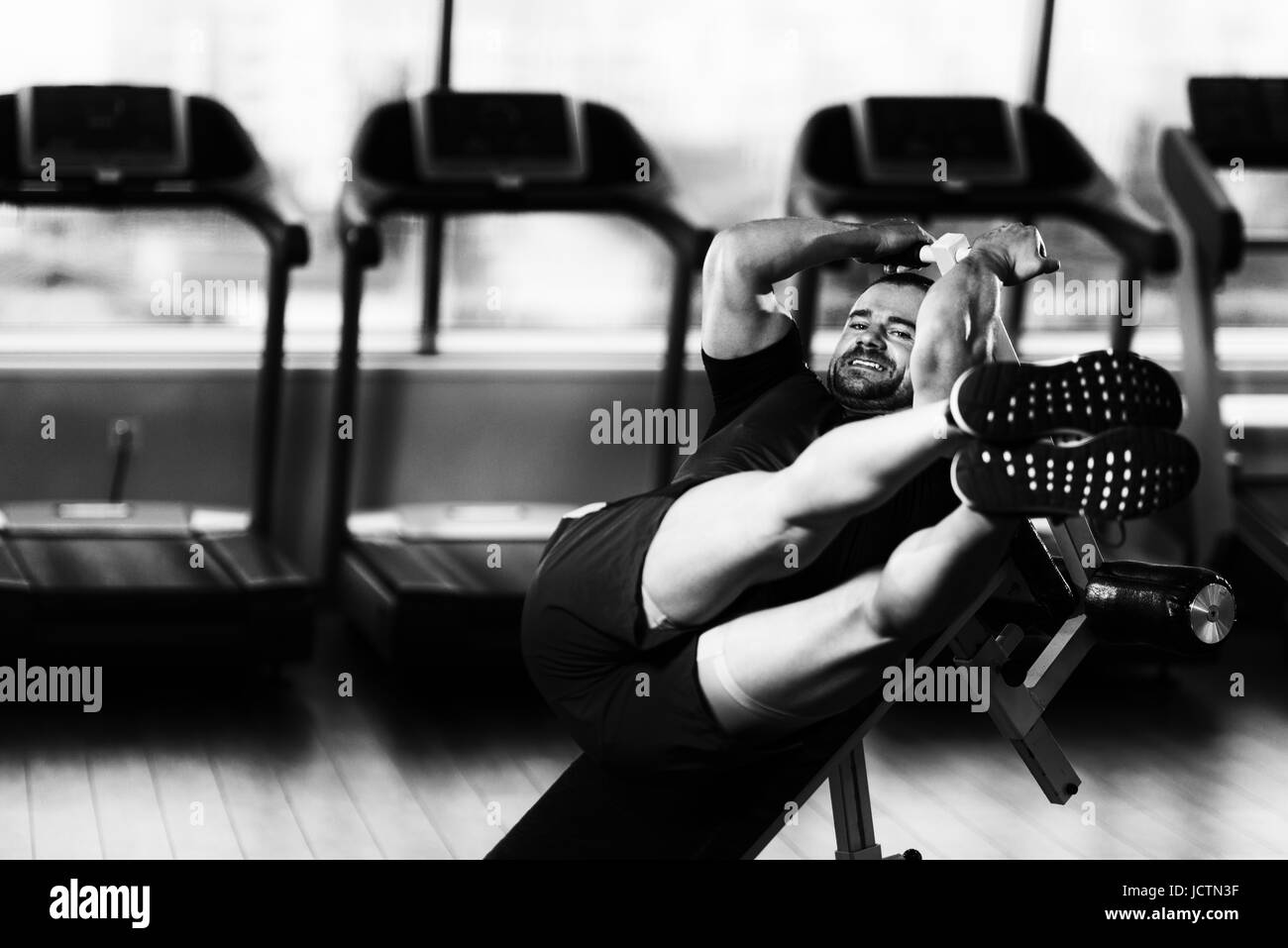 Fitness giovane uomo che lavora fuori Abs sul banco regolabile nel Centro Fitness Foto Stock