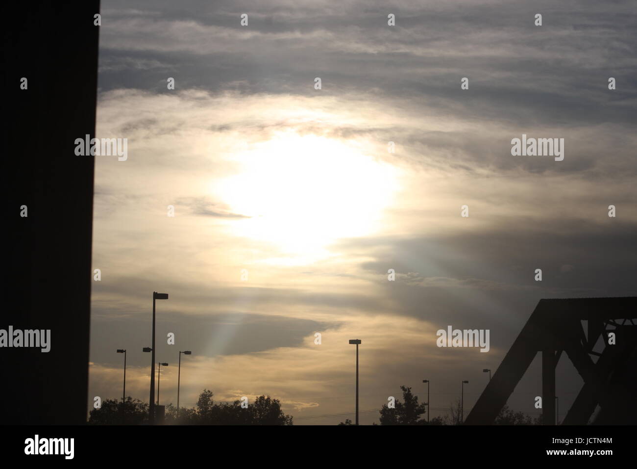 Un bel colpo di sole che splende luminosa attraverso le nuvole che circonda il sun. Foto Stock