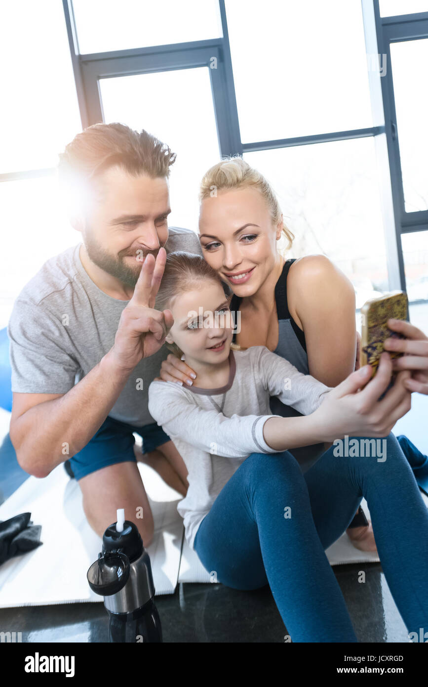 Ragazza tenendo autoritratto con i genitori al centro fitness Foto Stock