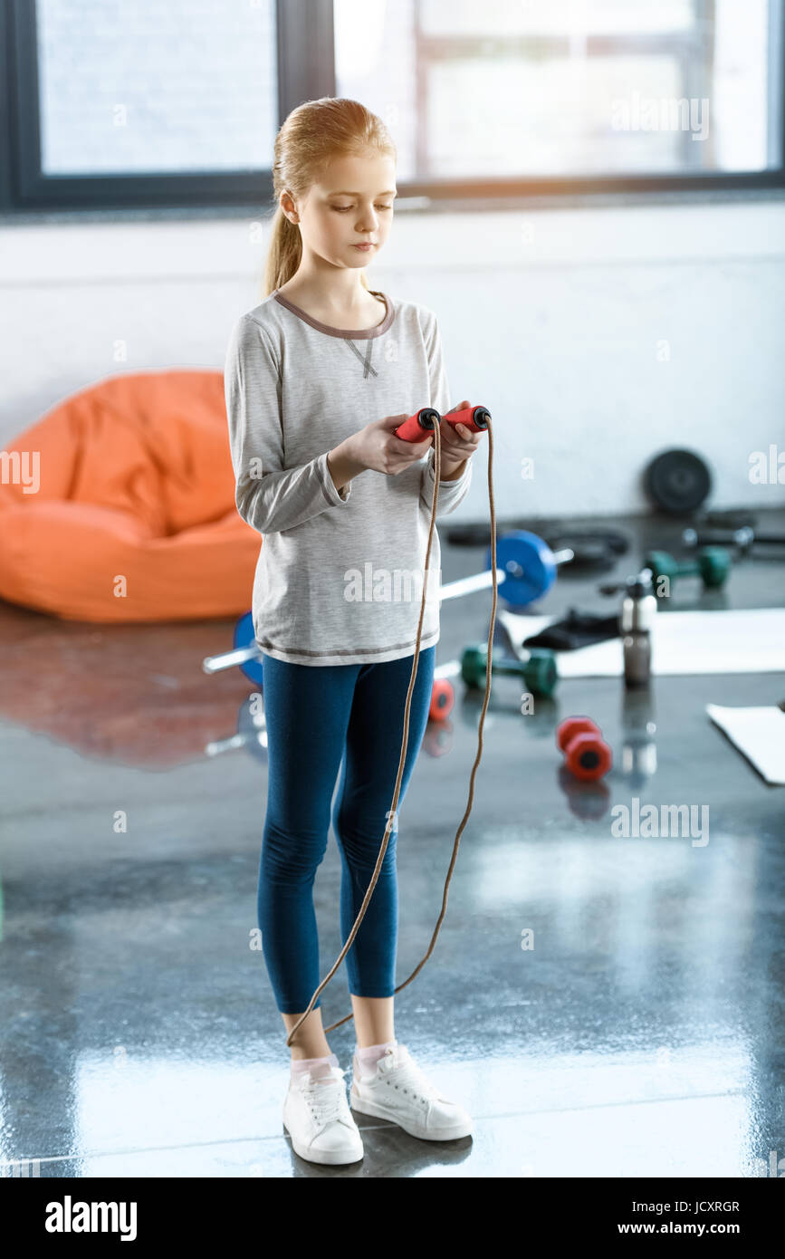 Ragazza giovane con la corda da salto in studio fitness Foto Stock