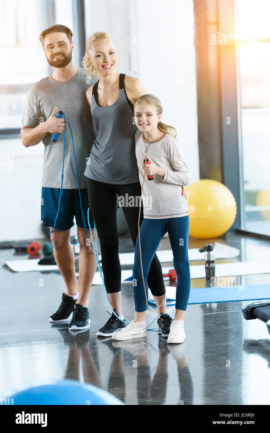 I giovani genitori e figlia con funi di salto al club della salute Foto Stock