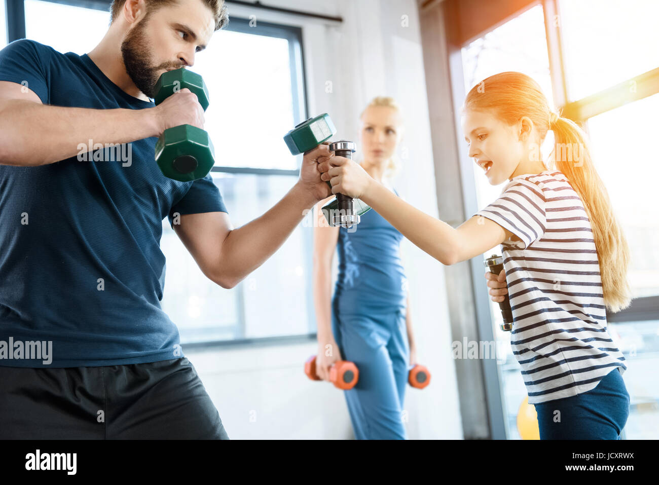 La famiglia felice esercizio con manubri in studio fitness Foto Stock
