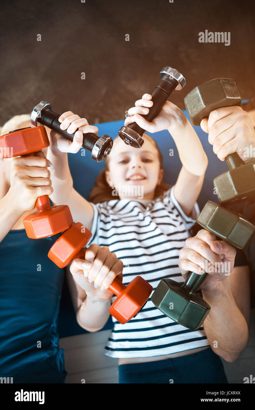 La famiglia felice esercizio con manubri in palestra per il fitness, pesi a forma di cuore Foto Stock