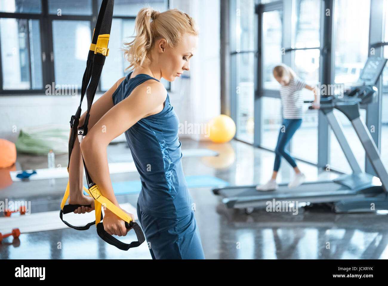 Bionda donna fitness training con trx cinghie di fitness Foto Stock