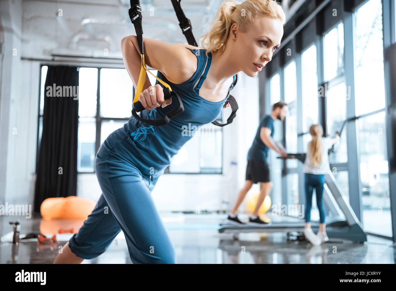Bionda donna fitness training con trx cinghie di fitness Foto Stock