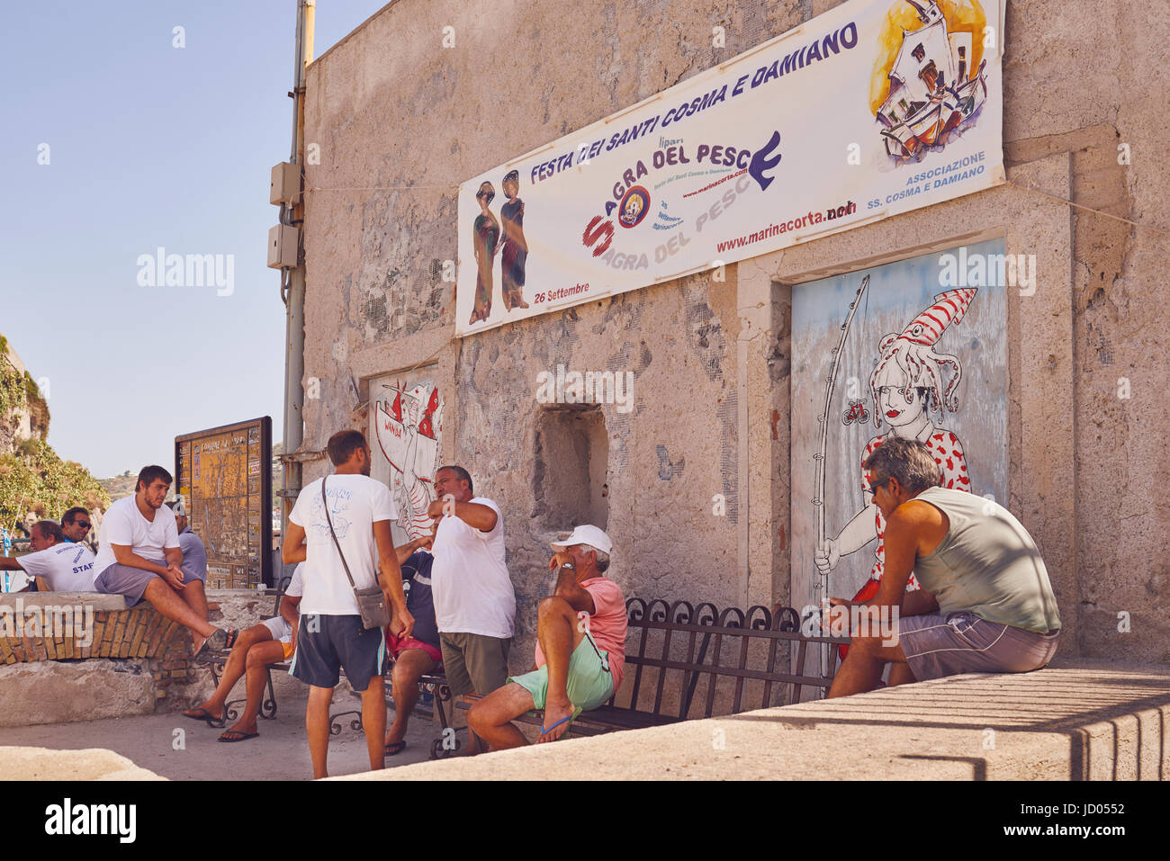 Isole Eolie o Lipari, Sicilia, Italia, Giugno 8 / 2016. Gli uomini a parlare tra di loro, graffiti tipici delle isole Eolie in background Foto Stock