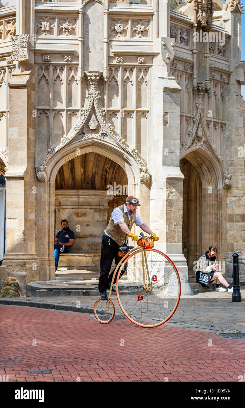 Uomo Barbuto equitazione replica moderna Penny Farthing bicicletta da Chichester Croce, una croce di mercato nel centro di Chichester, una città del West Sussex, Regno Unito Foto Stock