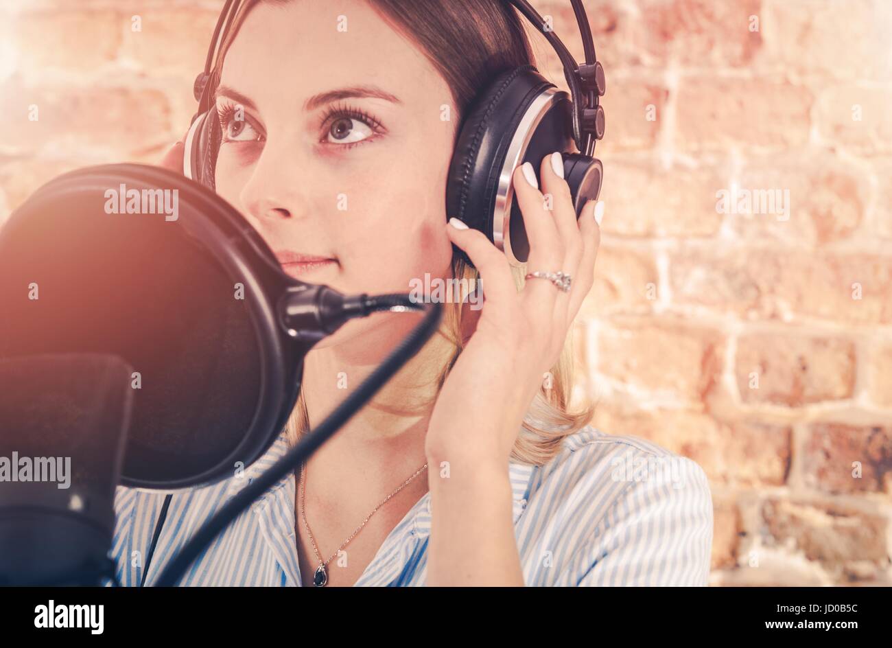 Ragazza caucasica nel suo 20s nella registrazione Audio Studio. Registrazione della voce. Foto Stock