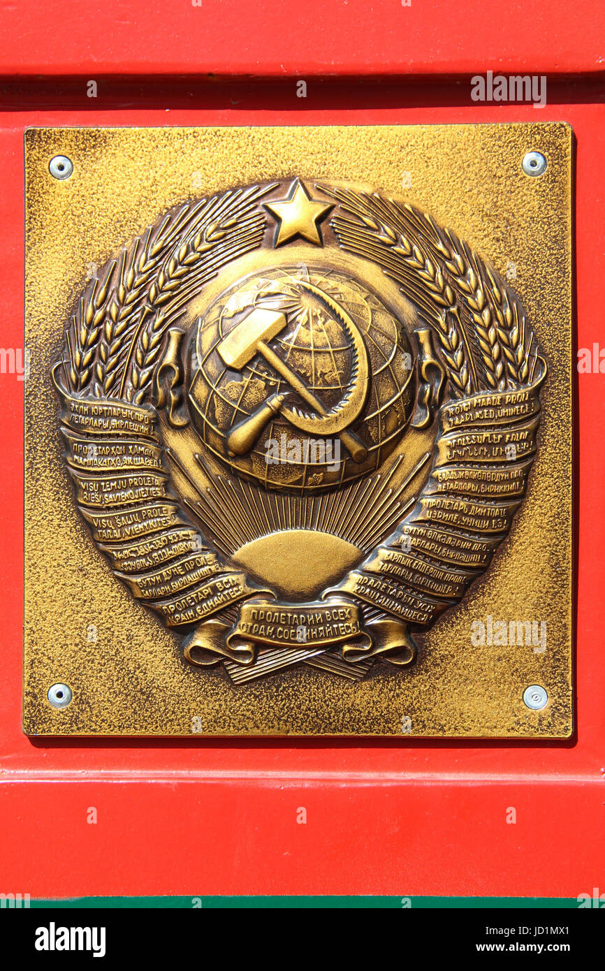 La piastra di metallo al posto di frontiera: Golden soviet CCCP - URSS emblema con falce e martello sul rosso-verde dello sfondo. Testo in diverse lingue. Foto Stock