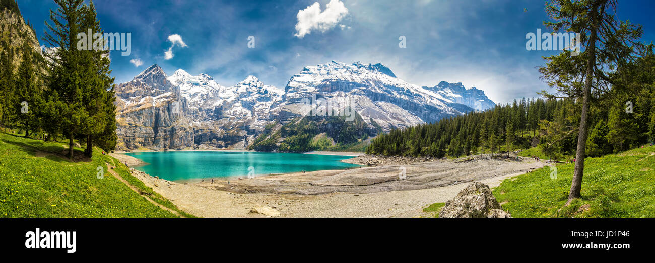 Incredibile tourquise Oeschinnensee con cascate, chalet in legno e Alpi Svizzere, Berner Oberland, Svizzera. Foto Stock