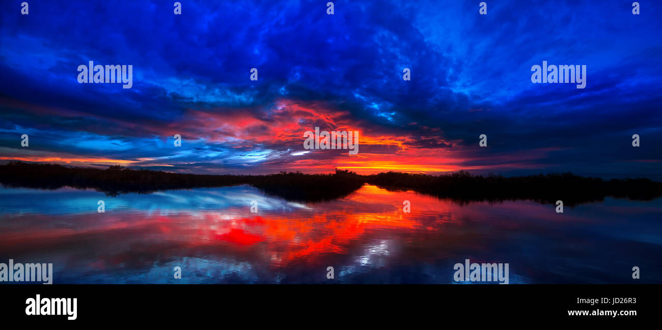 Un vivace e colorato tramonto riflette nelle acque della Florida Everglades su una bella serata estiva. Foto Stock