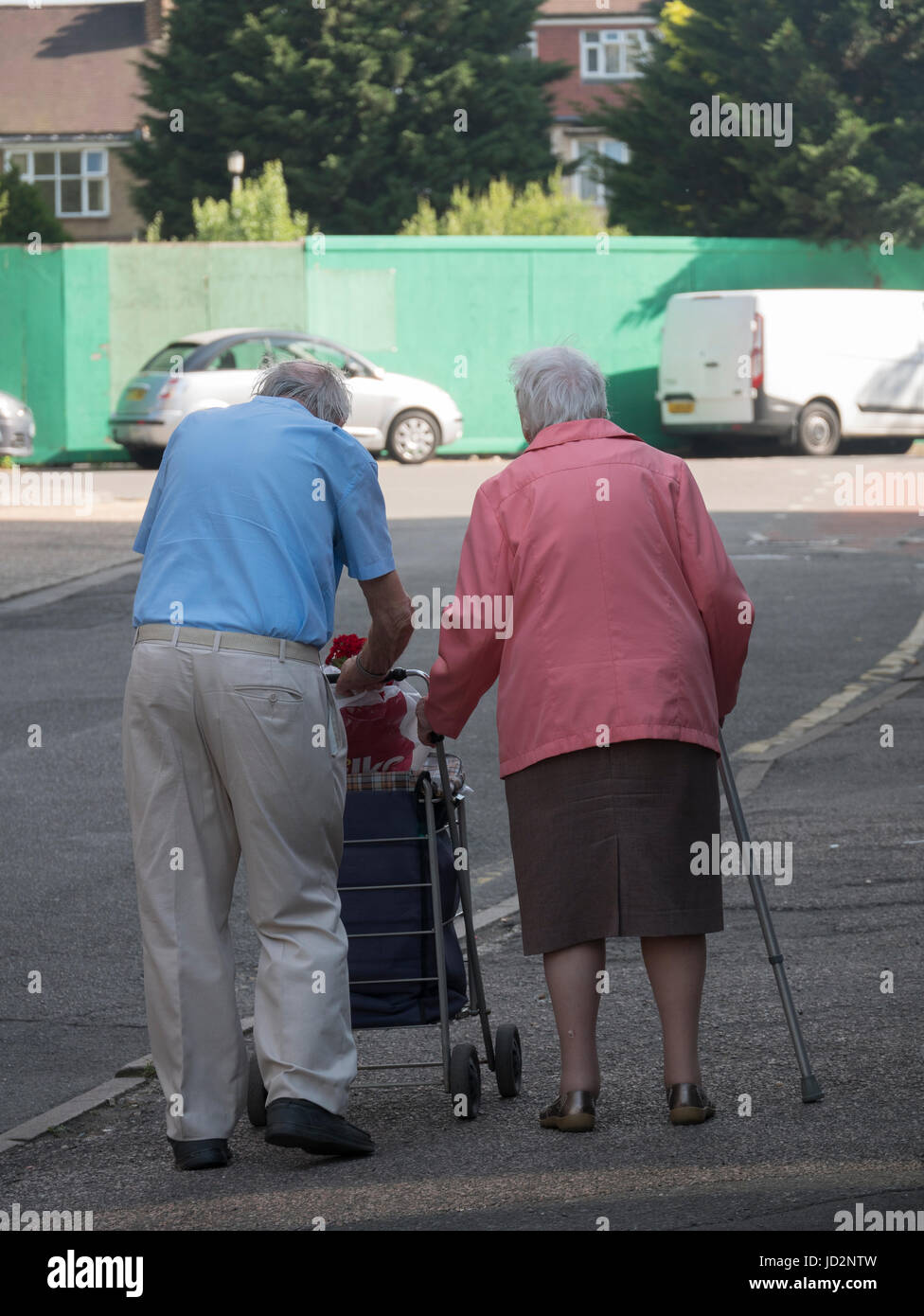 Un età matura con bastone e il carrello della spesa Foto Stock