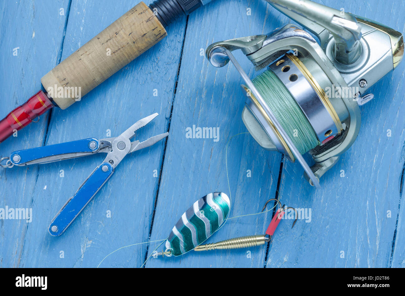 La filatura, aspo, pesca verde cucchiaio e le pinze. L'esca e lo strumento di un pescatore. Foto Stock