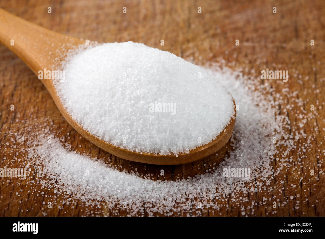 Cucchiaio di legno riempita con belle sale su sfondo di legno Foto Stock