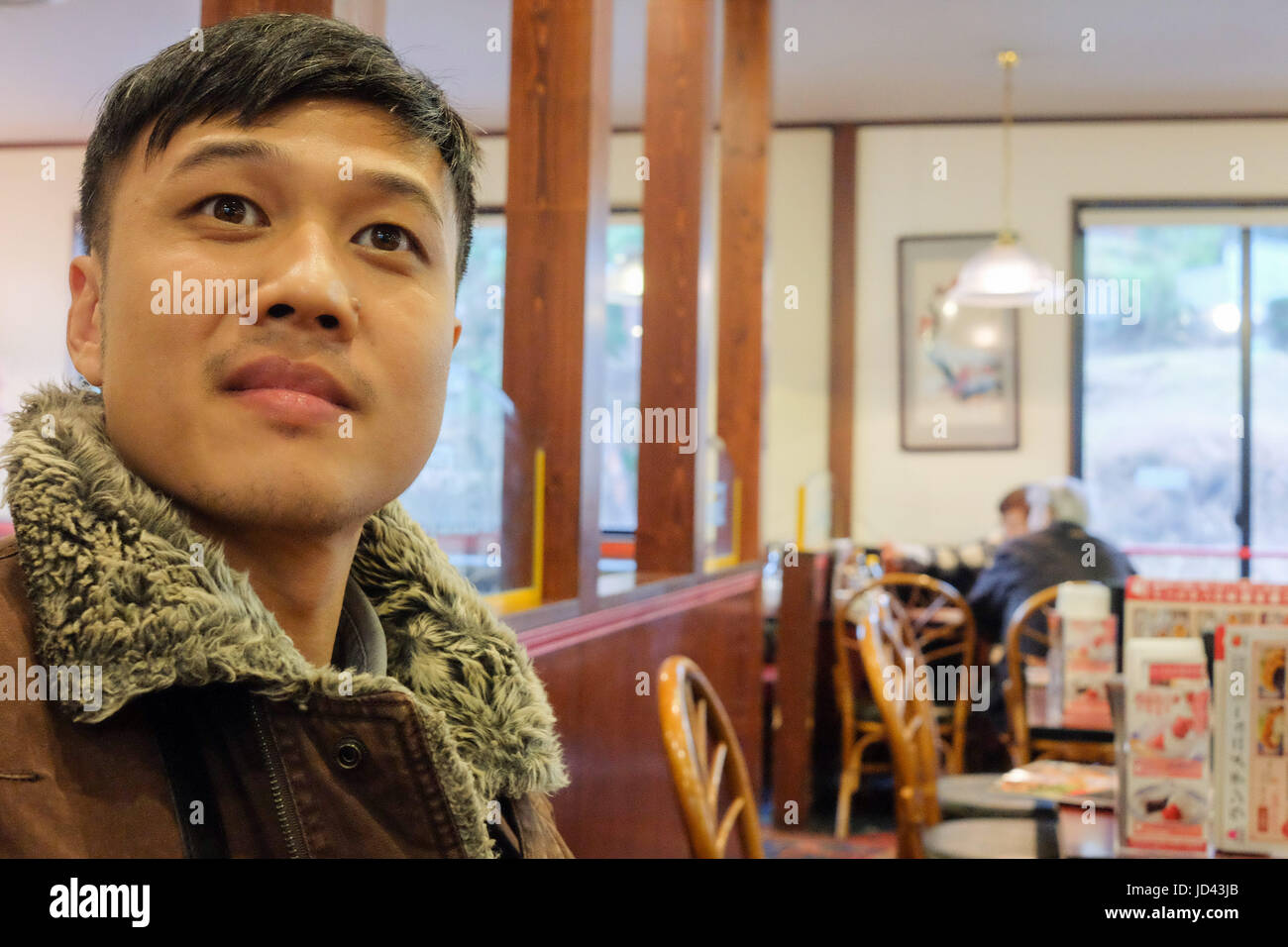 Uomo che guarda verso la telecamera al ristorante con sorpresa. Foto Stock